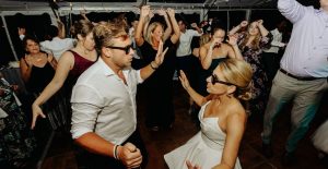 People dancing at an indoor party in a lively atmosphere.