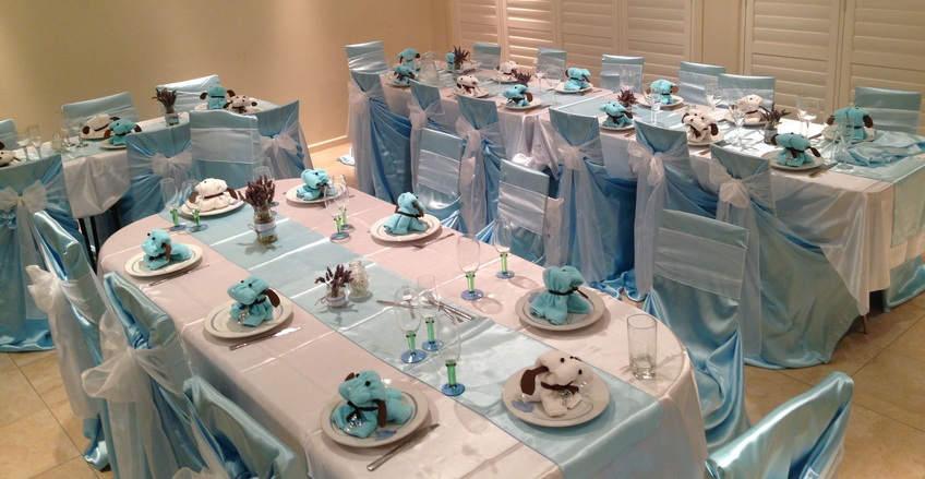 Elegant table decorations arranged for a baptism celebration, featuring floral centerpieces and neatly set tables.